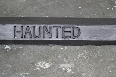 Black car stop with enscribed word "Haunted" in capital letters