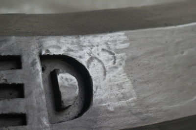 Close up of black car stop with the enscribed letter "D"