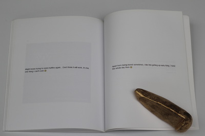 A book held open on a white table with golden skatestops as paper weights, left page reads "Might brave trying to cook muffins again... Don't think it will work, it's the one thing I can't cook sadface emoji", right page reads "Apart from being bored sometimes, i like this getting up early thing. i have the whole day then smiley"