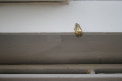 Golden skate stop on a white indoor window sill