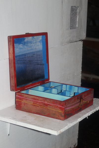 Red wooden box open with blue compartments inside