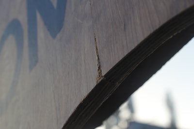 Close up of a tear in the surface of the wooden archway 