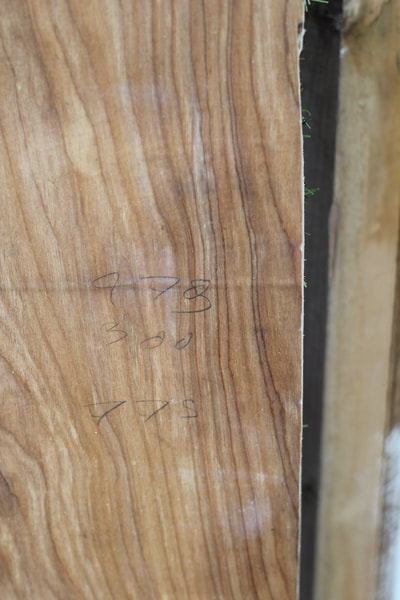 Close up of pencil measurement markings on the surface of the wooden archway